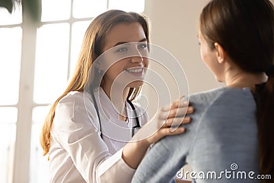 Smiling woman doctor sharing good news with happy female patient Stock Photo