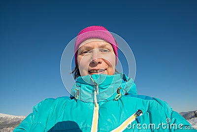 Smiling woman doing a photo of yourself in a sunny winter day in Stock Photo