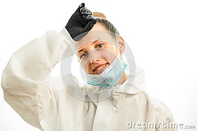 Smiling woman with downcast mask wipes her forehead with hand Stock Photo