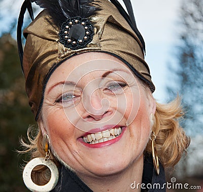 Smiling woman with earrings and a golden hat. Editorial Stock Photo