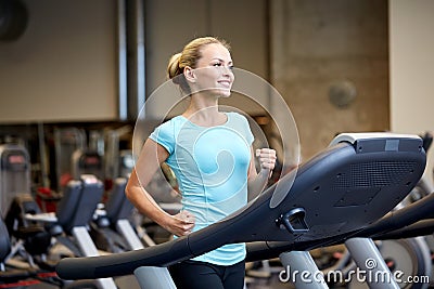 Smiling woman exercising on treadmill in gym Stock Photo