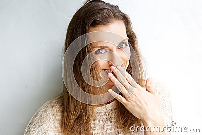 Smiling woman with hand covering mouth Stock Photo