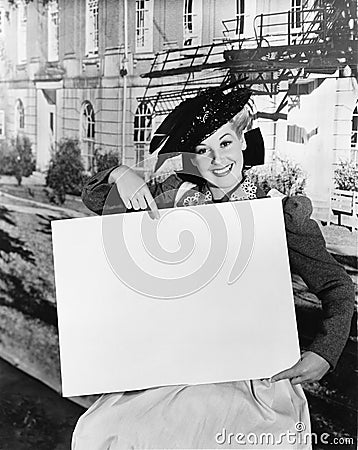 Smiling woman holding blank sign Stock Photo