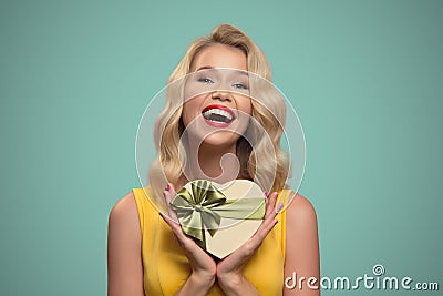 Young smiling woman holding gift. Valentine day. Stock Photo