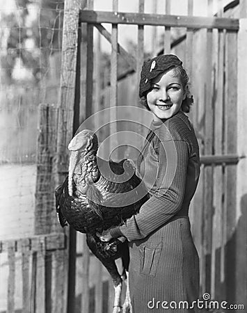 Smiling woman holding live turkey Stock Photo