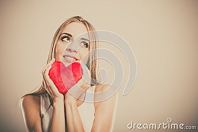 Smiling woman holding red heart love symbol Stock Photo