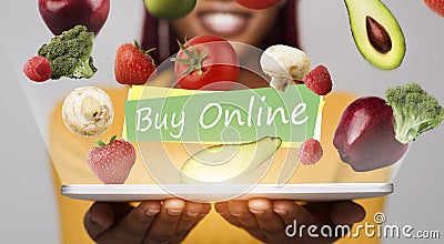 Smiling woman holding tablet with flying fruits and vegetables with text Stock Photo