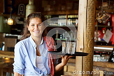 Smiling woman holding tray of drinks at a bar Stock Photo