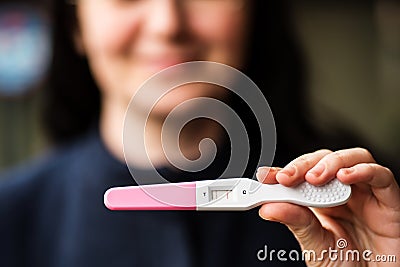 Smiling woman with home pregnancy test Stock Photo