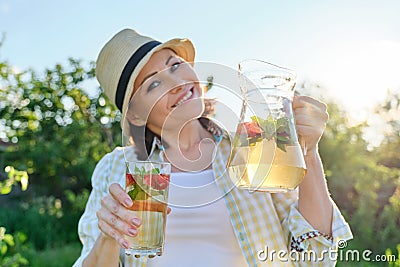 Smiling woman with jug of refreshing natural homemade drink Stock Photo