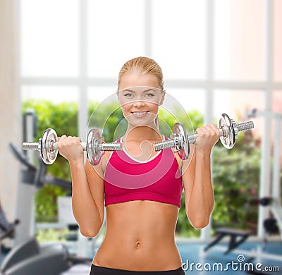 Smiling woman lifting steel dumbbells Stock Photo
