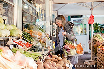 Smiling woman buying various vegetables Stock Photo