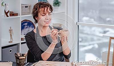 Smiling woman potter working at workshop Stock Photo