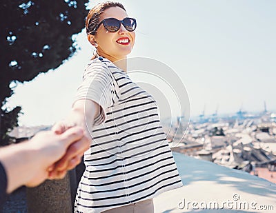 Smiling woman pulls for hand her boyfriend on the top view point Stock Photo