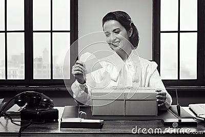 Smiling woman receiving a gift box by mail Stock Photo