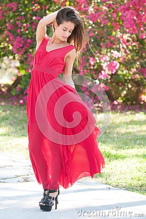 Smiling Woman in a red dress outside Stock Photo