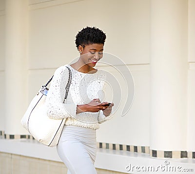 Smiling woman sending text message on mobile phone Stock Photo