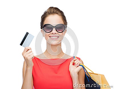 Smiling woman with shopping bags and plastic card Stock Photo