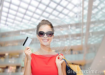 Smiling woman with shopping bags and plastic card Stock Photo