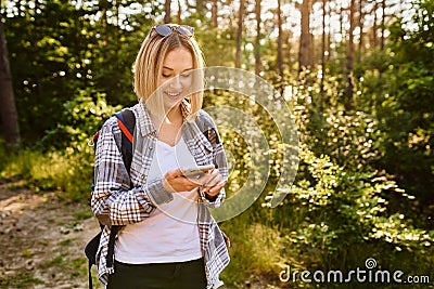 Smiling woman with smartphone during summer hike Stock Photo