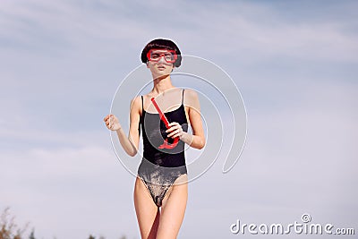 Smiling Woman Snorkeling in Red Fashion: Portrait of a joyful woman wearing a red swimsuit, snorkeling mask, and snorkel Stock Photo