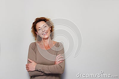 Smiling woman standing with arms crossed Stock Photo