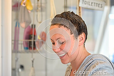 Smiling woman treating her hair with hair dye Stock Photo