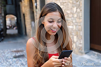 Smiling woman using mobile phone app to play video games online. Stock Photo