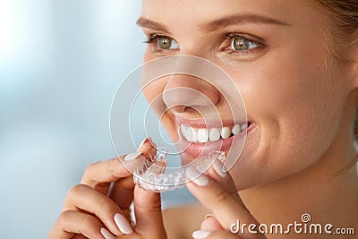 Smiling Woman With White Teeth Holding Teeth Whitening Tray Stock Photo