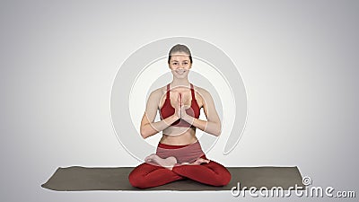 Smiling woman yoga meditating sitting lotus, hands coupled on gr Stock Photo