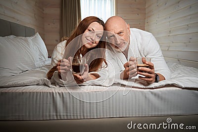 Spousal couple spending time in bedroom after morning awakening Stock Photo