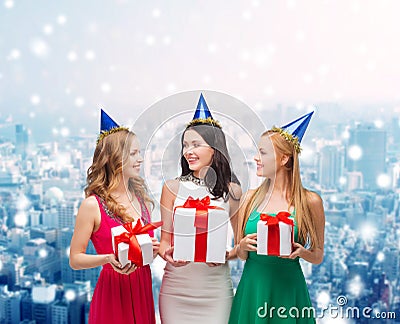 Smiling women in party caps with gift boxes Stock Photo