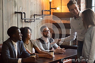 Smiling worker introducing new employee to colleagues during caf Stock Photo