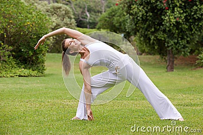 Smiling yoga woman stretching in the park Stock Photo