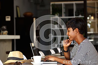 Smiling young african american woman working on laptop Stock Photo