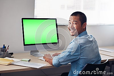 Smiling young Asian designer at work on an office computer Stock Photo