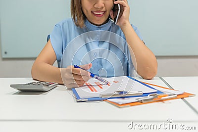 Smiling young Asian woman talking on mobile phone Stock Photo