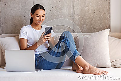 Smiling young asian woman using mobile phone Stock Photo