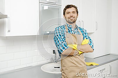 Smiling Young Bearded Brunet in Household Gauntlets and Apron Stock Photo