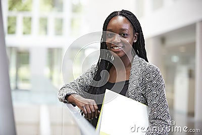 Smiling young black female student in university foyer Stock Photo