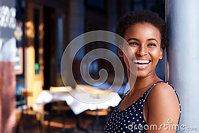 Smiling young black woman standing outside Stock Photo