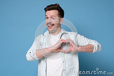 Smiling young boy making heart gesture on his chest. Valentine day concept. Stock Photo