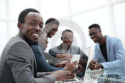 Smiling young businessman sitting at office Desk Stock Photo