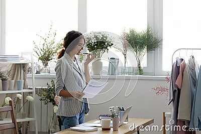 Smiling young businesswoman activating voice recognition assistant on mobile phone. Stock Photo