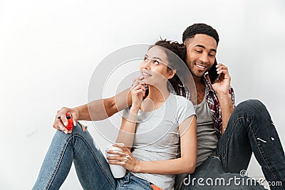 Smiling young couple drinking coffee and talking on cell phone Stock Photo
