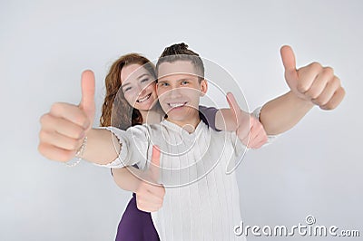 Smiling young couple showing thumbs up Stock Photo