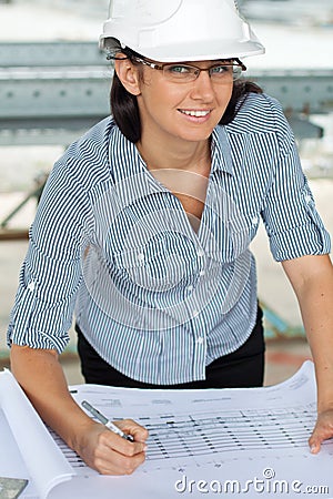 Smiling young engineer woman revises a drawing Stock Photo