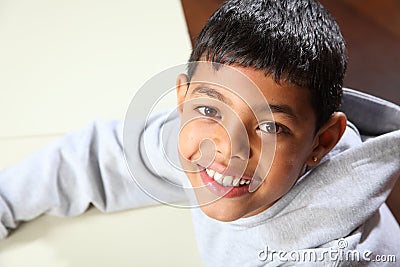 Smiling young ethnic school boy wearing grey hoodi Stock Photo