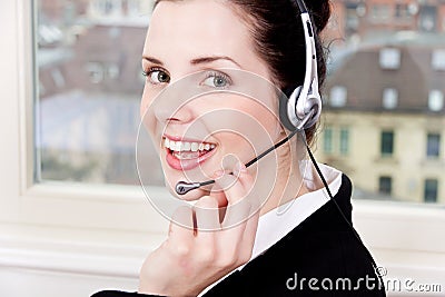 Smiling young female callcenter agent with headset Stock Photo