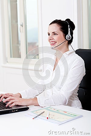 Smiling young female callcenter agent with headset Stock Photo